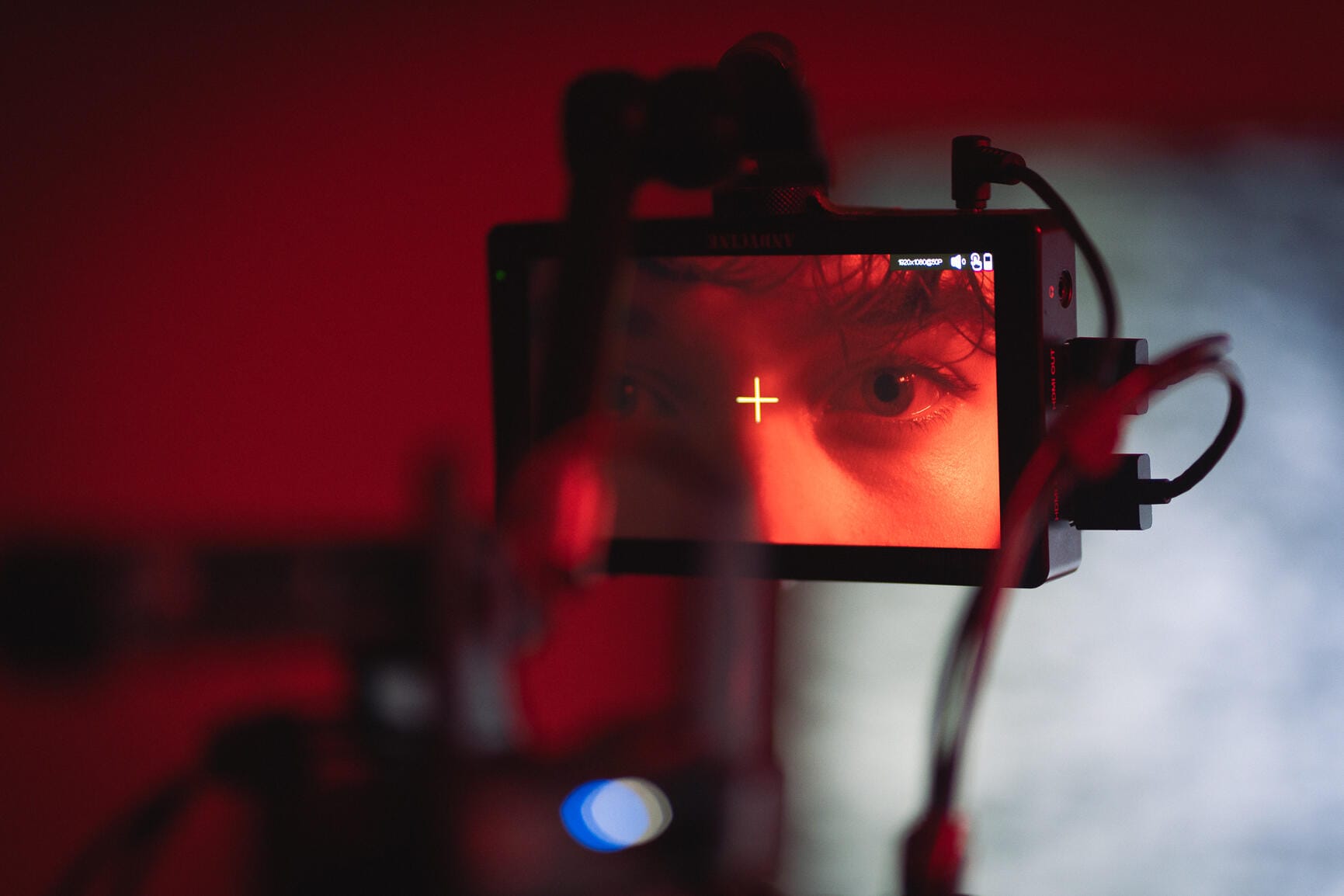 Kino kamera ir monitorius raudoname apšvietime – profesionalus video filmavimas