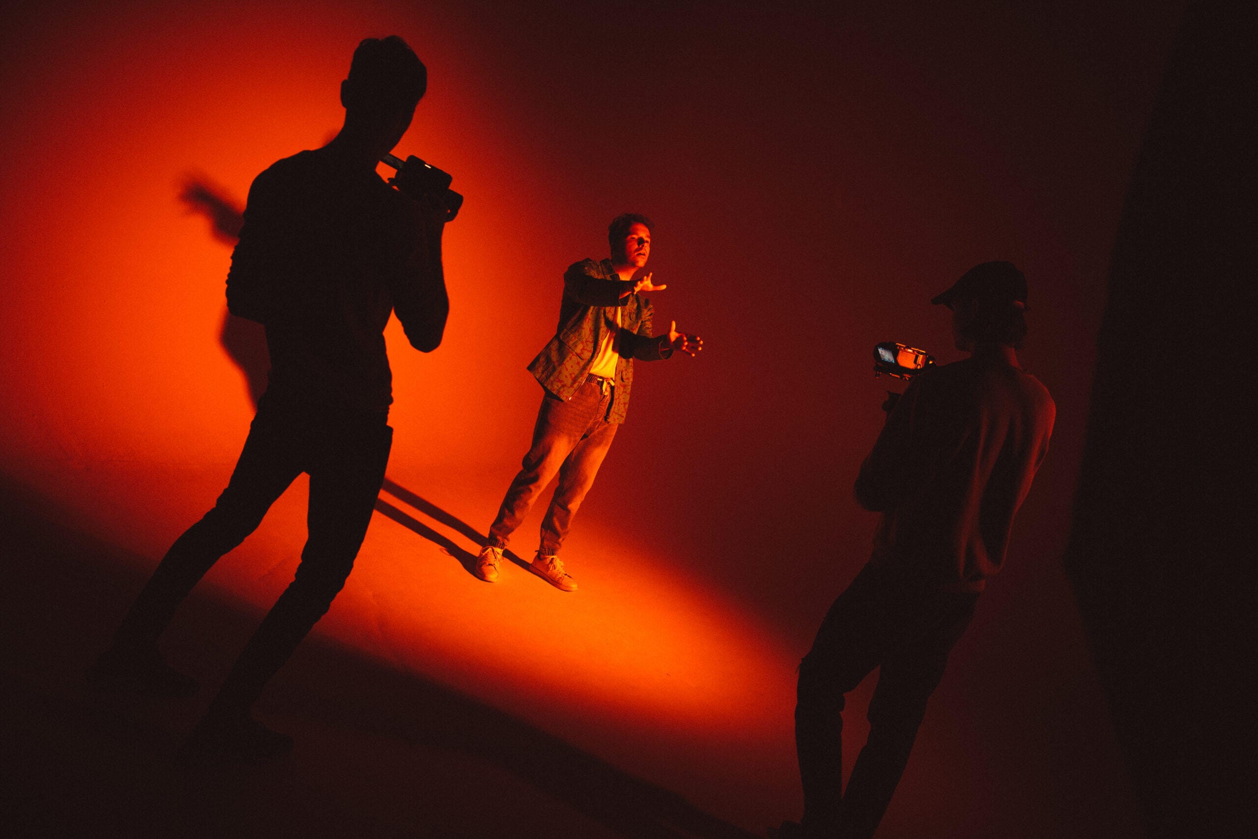 Šokėja scenoje oranžiniame apšvietime – muzikinių klipų filmavimas